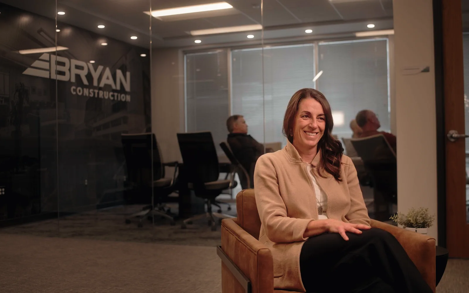 A smiling construction professional sits for an interview in a Bryan Construction office.