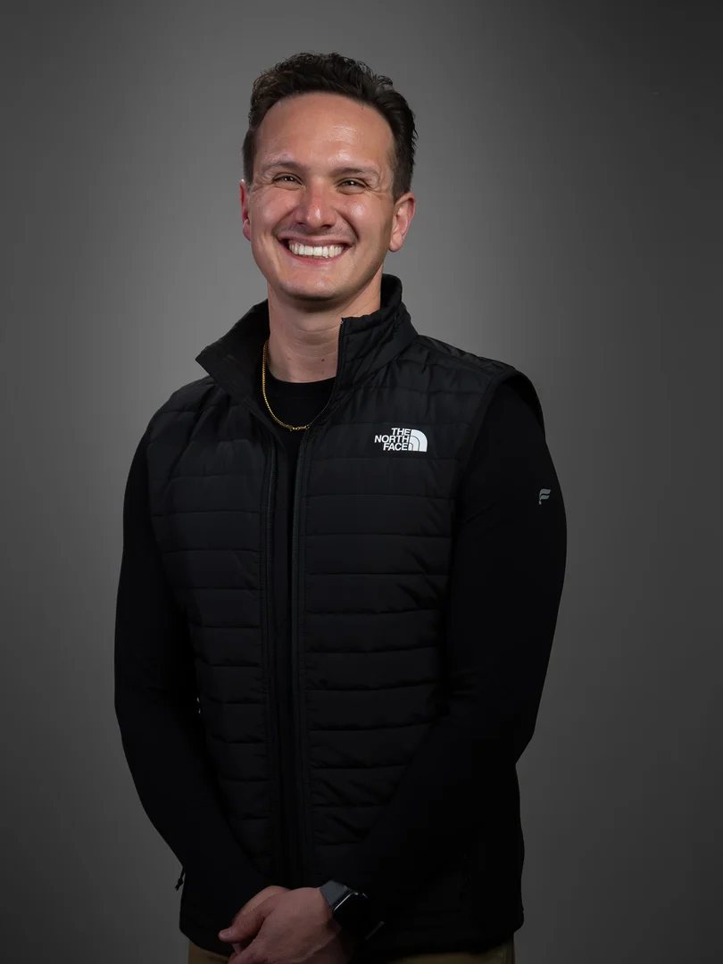 Zach Watkins smiling in a studio portrait